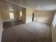 Spacious living room with plush carpeting, neutral walls, and abundant natural light at 5138 Rock Dove Trl, Lakeland, FL 33810