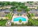 Overhead shot of community pool, nearby parking, and surrounding condo buildings with mature trees at 519 Sandstone St, Lakeland, FL 33809
