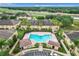 Aerial view featuring a community pool with cabana, manicured landscaping, and nearby highway at 519 Sandstone St, Lakeland, FL 33809