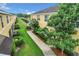 Townhome backyard featuring a green lawn, mature trees, and a walkway, with a pond beyond at 519 Sandstone St, Lakeland, FL 33809