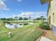 A calming backyard view of a pond, with grassy banks, blue skies, and clouds reflecting in the water at 519 Sandstone St, Lakeland, FL 33809