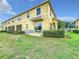 Home exterior boasting a well-manicured lawn, tidy bushes, and a sliding glass door leading to a screened patio at 519 Sandstone St, Lakeland, FL 33809