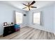 Bedroom with light blue walls, wood-look floors, and a ceiling fan at 519 Sandstone St, Lakeland, FL 33809