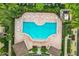 Aerial view of a uniquely shaped community pool with lounge seating, a covered area, and lovely landscaping at 519 Sandstone St, Lakeland, FL 33809