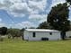 Back exterior of home, showing fenced yard, AC unit, and a tree with a large trunk at 5217 Turtle Dove Trl, Lakeland, FL 33810