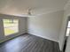 A bright bedroom featuring updated floors, a ceiling fan, and a large window for natural light at 5217 Turtle Dove Trl, Lakeland, FL 33810