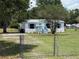 Charming home with fenced yard, well-maintained lawn, light blue painted porch, and matching shutters at 5217 Turtle Dove Trl, Lakeland, FL 33810