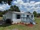 Charming home with light blue painted porch, matching shutters, a well-maintained lawn, and a metal roof at 5217 Turtle Dove Trl, Lakeland, FL 33810