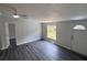 A freshly painted living room with new gray floors, a ceiling fan, and a view of the yard at 5217 Turtle Dove Trl, Lakeland, FL 33810