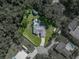 Aerial view showcasing the home, pool area, outbuildings, green spaces, and surrounding trees at 5427 Orange Valley Dr, Lakeland, FL 33813