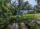 Picturesque backyard with a tranquil creek, a fire pit, and cozy seating, perfect for enjoying nature's beauty at 5427 Orange Valley Dr, Lakeland, FL 33813