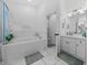 Bright bathroom featuring a soaking tub, a shower, dual sinks, and tile flooring at 5427 Orange Valley Dr, Lakeland, FL 33813