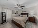 Primary bedroom features a plush queen bed, ceiling fan, decor, and soft natural lighting at 5427 Orange Valley Dr, Lakeland, FL 33813
