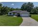 Charming single-story home featuring a well-manicured lawn, white picket fence, and an attached two-car garage at 5427 Orange Valley Dr, Lakeland, FL 33813