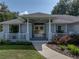 Inviting front porch with decorative columns, a charming entrance, and lovely landscaping for a welcoming appeal at 5427 Orange Valley Dr, Lakeland, FL 33813