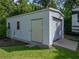 Exterior shot of outbuilding with garage door, metal siding, window, door, and green grass at 5427 Orange Valley Dr, Lakeland, FL 33813