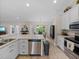 Bright kitchen featuring white cabinets, stainless steel appliances, and an island with a sink and plenty of counter space at 5427 Orange Valley Dr, Lakeland, FL 33813