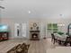 Open-concept living space with a fireplace, dining area, and natural light from the windows and doors at 5427 Orange Valley Dr, Lakeland, FL 33813