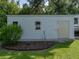 Exterior shot of outbuilding with metal siding, windows, door, and small landscaped area with flower bed at 5427 Orange Valley Dr, Lakeland, FL 33813