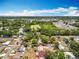 Aerial view of neighborhood with trees and green areas under blue sky at 603 Solana St, Lakeland, FL 33813