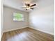 Empty bedroom featuring wood-look flooring, window, and ceiling fan at 603 Solana St, Lakeland, FL 33813