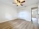 Bright bedroom features neutral walls, ceiling fan, wood-look floors and closet at 603 Solana St, Lakeland, FL 33813