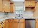 Close-up of a kitchen area with wood cabinets, granite countertops, and stainless steel appliances at 603 Solana St, Lakeland, FL 33813