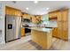 Well-lit kitchen featuring stainless steel appliances, a granite countertop island, and wood cabinets at 603 Solana St, Lakeland, FL 33813