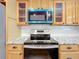 Close-up showcasing kitchen appliances including a range and microwave, surrounded by granite countertops and cabinets at 603 Solana St, Lakeland, FL 33813