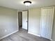 Bedroom with laminate flooring, neutral walls, closets, and a doorway to an adjacent room at 6611 Glen Meadow Loop, Lakeland, FL 33810