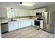 Modern kitchen with stainless steel appliances, white cabinets, and luxury vinyl plank flooring at 6611 Glen Meadow Loop, Lakeland, FL 33810