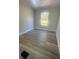 Clean and cozy bedroom featuring luxury vinyl flooring and a bright window with natural light at 7005 Dove Meadow Trl, Lakeland, FL 33810