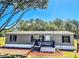 Charming gray home with a manicured lawn, updated windows, and a welcoming front porch at 7005 Dove Meadow Trl, Lakeland, FL 33810