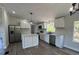 Modern kitchen featuring white cabinets, stainless steel appliances, an island, and luxury vinyl flooring at 7005 Dove Meadow Trl, Lakeland, FL 33810