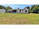 View of backyard, showcasing the home's screened porch and well-maintained lawn at 733 S Clayton Ave, Lakeland, FL 33801