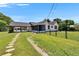Charming white house with black trim, a covered parking area, screened in porch, and a fenced yard at 733 S Clayton Ave, Lakeland, FL 33801