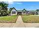 Charming two-story home with a well-manicured lawn, beautiful landscaping, and a convenient covered parking area at 733 S Clayton Ave, Lakeland, FL 33801
