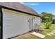 Detached garage featuring horizontal siding, a white door, an exterior light and new landscaping at 733 S Clayton Ave, Lakeland, FL 33801