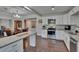 Open kitchen with white cabinets, stainless steel appliances, granite countertops, and wood-look floors at 733 S Clayton Ave, Lakeland, FL 33801