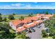 Aerial view of waterfront townhomes featuring tile roofs, private garages, and lush greenery along a picturesque lakefront at 804 Magnolia Pl # 804, Winter Haven, FL 33884