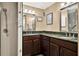 This bathroom features dual sinks with wood cabinets, framed mirrors, and a walk-in shower at 804 Magnolia Pl # 804, Winter Haven, FL 33884