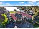 Aerial view of a clubhouse with a red tile roof and lake view surrounded by lush landscaping and ample parking at 804 Magnolia Pl # 804, Winter Haven, FL 33884