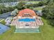 Aerial view of the community pool with lounge seating, hot tub, clubhouse, shuffleboard, landscaping and green space at 804 Magnolia Pl # 804, Winter Haven, FL 33884