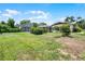 Sprawling backyard with lush greenery and a screened-in pool enclosure, ideal for outdoor enjoyment at 900 Howard Nw Ter, Winter Haven, FL 33881