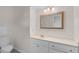 Clean bathroom with white vanity, decorative mirror, and a toilet at 900 Howard Nw Ter, Winter Haven, FL 33881