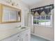 Bright bathroom featuring white vanity, marble countertop, and window at 900 Howard Nw Ter, Winter Haven, FL 33881