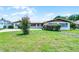 Charming single-story home featuring a metal roof, green shutters, and lush front yard at 900 Howard Nw Ter, Winter Haven, FL 33881
