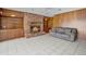 Bright living room featuring a brick fireplace, wood paneling, and white tile flooring at 900 Howard Nw Ter, Winter Haven, FL 33881