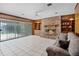 Inviting living room featuring a brick fireplace, wood paneling, and sliding glass doors at 900 Howard Nw Ter, Winter Haven, FL 33881