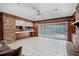 Bright living room with pool view, brick accent wall, and tile flooring at 900 Howard Nw Ter, Winter Haven, FL 33881